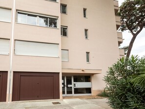 Stylish building with modern architecture, featuring a mix of closed and open windows and a small entrance with glass doors.