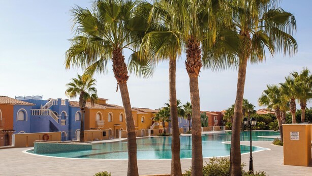 A pool area with palm trees and buildings in the background. - SANDRINE apartment in Benitachell – 2 terraces, swimming pool, air conditioning and Wi-Fi, 1.8 km from Cala Moraig (Benitachell)