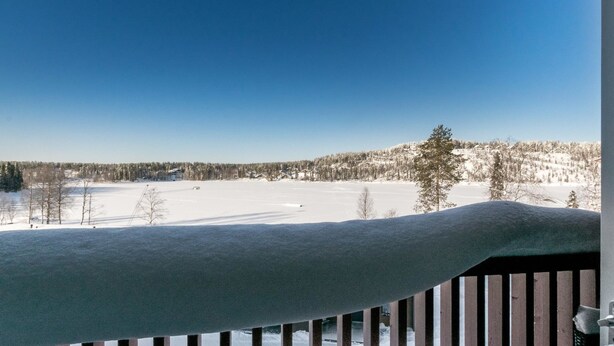 A balcony with a view of a snowy landscape, including a forest and a clear sky. - Skivillas 61 ukkohalla (b8) by Interhome (Hyrynsalmi)
