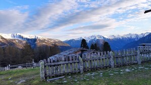 A mountainous landscape with a wooden fence and a small building. - Vacation Apartment "Golserhof Sonne" in the Ahrntal Valley with Mountain View (Steinhaus Ahrntal)