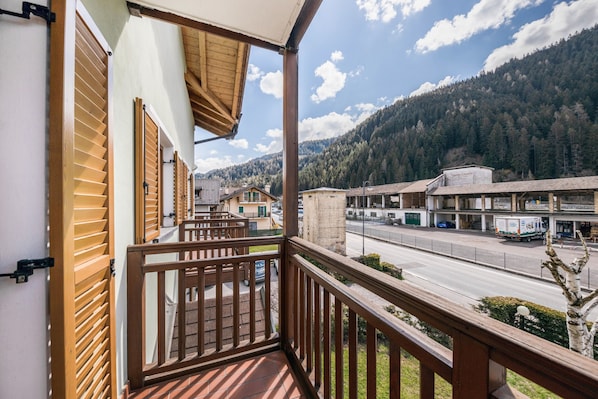 Un balcon donnant sur une rue et des montagnes.