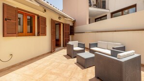 A courtyard with outdoor seating and a building with wooden shutters.