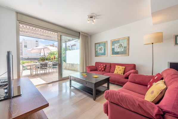 A modern living room with a sofa set, a coffee table, and a TV.