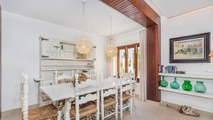 A dining area with a white table and chairs, hanging wicker chandeliers, and a wooden ceiling. - In perfect location to beach and city - Villa Hibiscus (Pollensa)