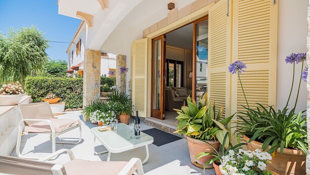 An outdoor patio with chairs, a table, and potted plants. - In perfect location to beach and city - Villa Hibiscus (Pollensa)
