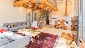 A spacious living area with a staircase, a dining area, and a kitchen. - Unique Country House In Central Israel (Hefer Valley)