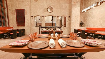 Un comedor con una amplia mesa de madera dispuesta para una comida, rodeado de sillas.
