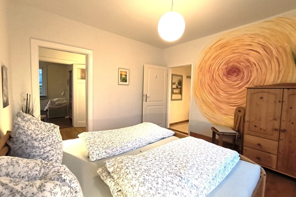 Schlafzimmer mit Doppelbett und anliegendem Bad