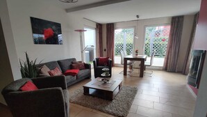Ein Wohnzimmer mit Sofa, Couchtisch und einem Essbereich mit Stühlen und einem Tisch.