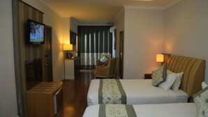 A hotel room with two beds, a television, a desk, and a chair. - Bonanza Addis Hotel (Addis Ababa)