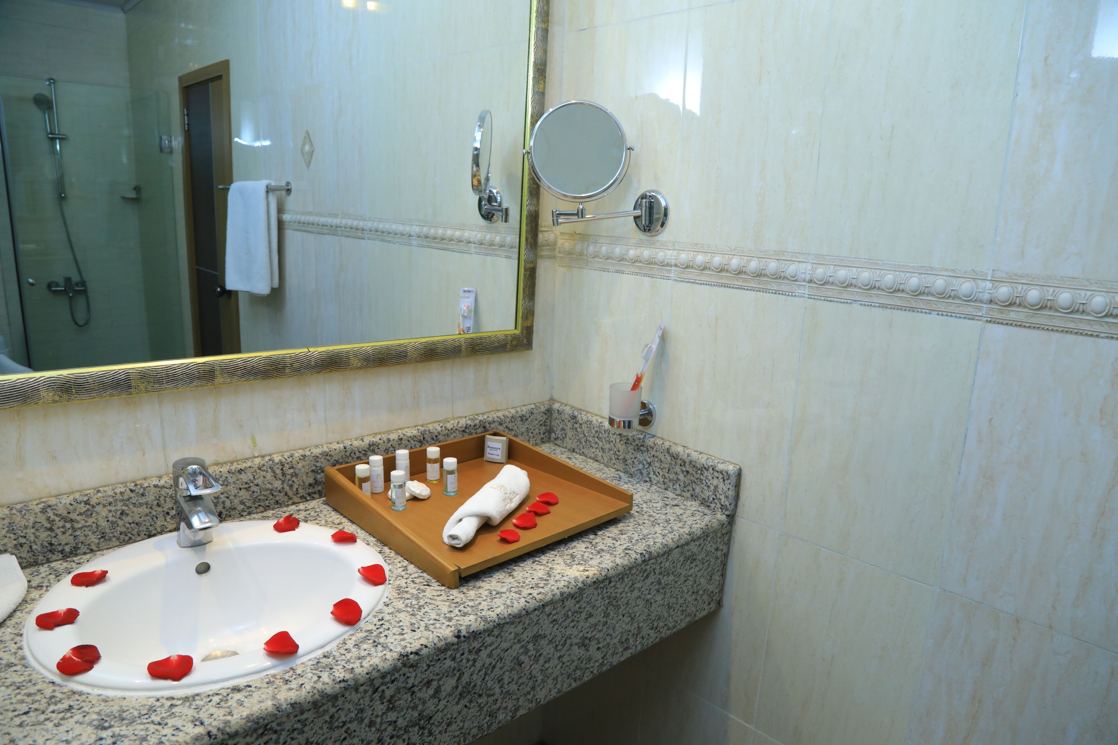 Un baño con lavamanos, espejo y ducha.
