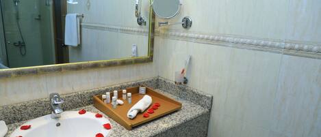 Un baño con lavamanos, espejo y ducha.