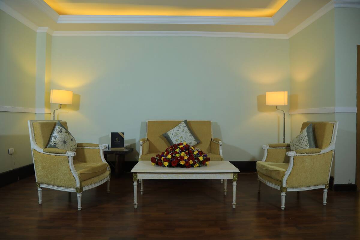 A room with two armchairs, a central coffee table, and two lamps.