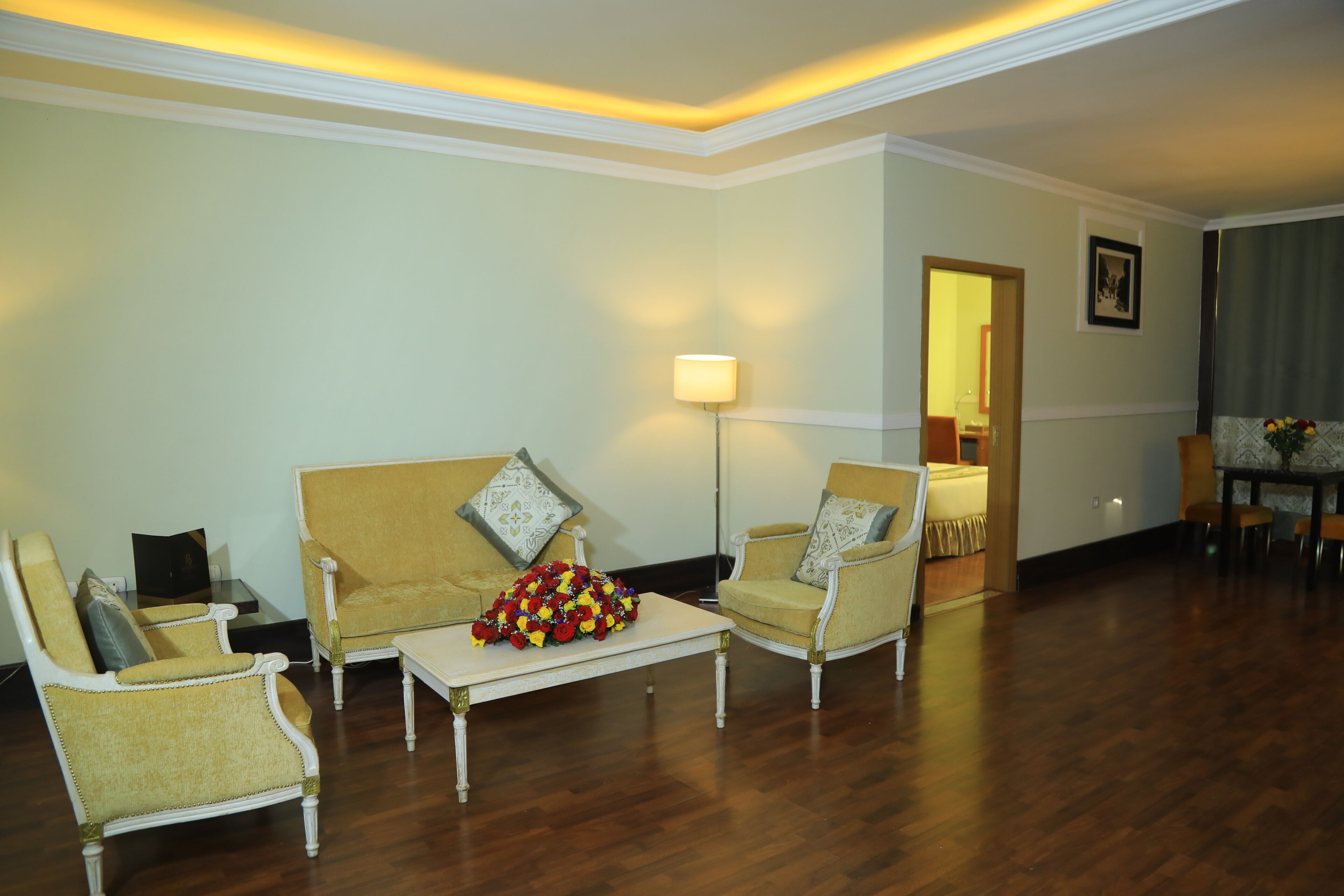 A living room with a sofa, armchairs, a coffee table, and a lamp.