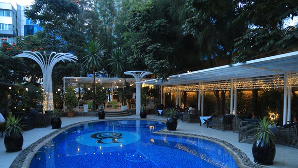 A pool area with a fountain, seating, and a covered patio. - Bonanza Addis Hotel (Addis Ababa)