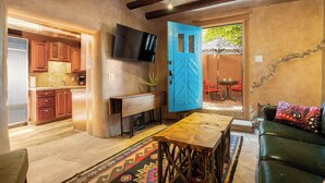 Una sala acogedora con una mesa de centro de madera, un sofá y un televisor montado en la pared.