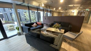 A modern interior with a sectional sofa, a coffee table, and a seating area with a small table and chairs.
