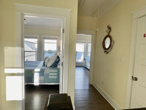 A bedroom with a bed, a view of the outside balcony, and a door with a number.