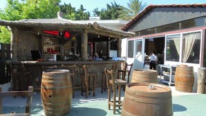 Un espace extérieur aménagé en terrasse, avec des tonneaux en bois, un bar et des sièges.