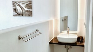 A modern bathroom with a white sink, a mirror, and a towel rack. - Queen Double Room by Bianco a Nero Mykonos (Πλιντρί)