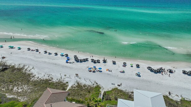 An aerial view of a beach with tents and umbrellas, a sandy shore, and the ocean. - Private Beach, Pickleball, Tennis 3 heated pools! (Santa Rosa Beach)