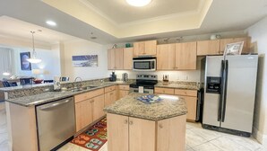 A modern kitchen with granite countertops, stainless steel appliances, and wooden cabinets.