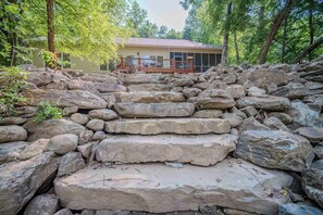 A stone staircase leading to a house surrounded by trees.