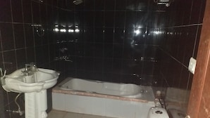 A bathroom with a sink, toilet, and bathtub. - Achal's जंगल में मंगल (Gurugram)