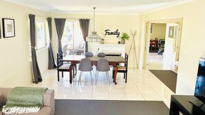 Un comedor con una mesa y sillas, un sofá, un televisor y una chimenea.