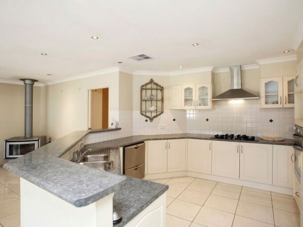 Enjoy cooking in this well-equipped kitchen with a curved countertop, stove, and integrated sink.