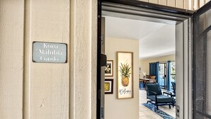 A sign reading "Kona Maluhia Condo" at the entrance of a building.