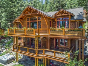 A multi-level wooden cabin with balconies, surrounded by trees. - Lake View 545 Lodgepole | 6BR/6.5BA Incline | Hot Tub, Game Room (Incline Village)
