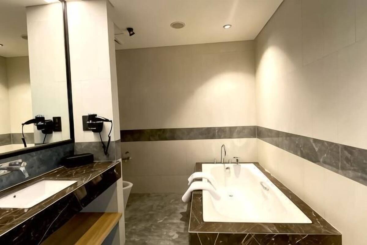 A modern bathroom with two sinks, a large mirror, and a marble countertop.
