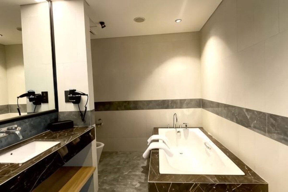 A modern bathroom with two sinks, a large mirror, and a marble countertop.