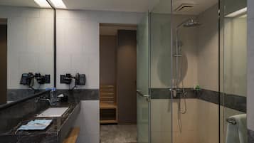 A modern bathroom with a glass-enclosed shower, a marble sink, and a wooden bench.
