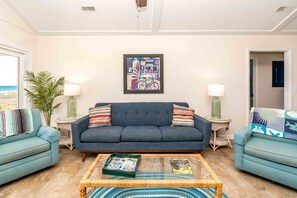A living room with a sofa, two armchairs, a coffee table, and a framed picture on the wall. - Summer Girl - Oceanfront! 4 Bedroom Cottage (Topsail Beach)