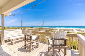 A wooden deck with Adirondack chairs overlooking a beach. - Summer Girl - Oceanfront! 4 Bedroom Cottage (Topsail Beach)