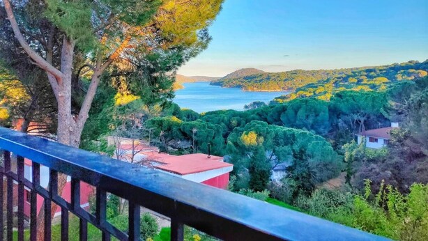 A balcony overlooking a coastal landscape with trees and a view of the sea. - Casa Rural La Goleta.  Pantano de San Juan (San Martín de Valdeiglesias)