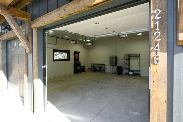 Un grand garage doté d’un sol en béton, d’un cadre de porte en bois et du numéro « 21246 » peint sur le mur.