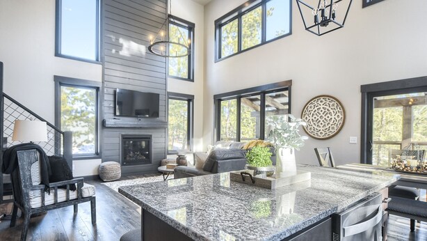 A spacious kitchen with a large island, a built-in fireplace, and a television mounted on the wall.