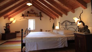 A bedroom with a wooden ceiling, a bed with white bedding, a nightstand, a dresser, and a window. - Villa Dol (Postira)