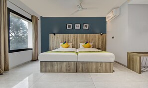 Una cama doble con cabecera de madera, dos almohadas y una mesita de noche.
