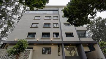 Un immeuble à plusieurs étages doté d’une architecture moderne, caractérisé par une série de fenêtres et un toit plat.