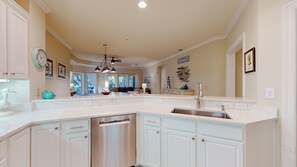A spacious kitchen with white cabinetry, a stainless steel dishwasher, and a large island with a sink. - 8138 Wendover Dunes- Large Updated Villa Steps from the Beach! (Hilton Head)