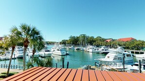 A marina with multiple boats docked, surrounded by palm trees and buildings. - Completely Updated Two Bedroom Condominium with Sweeping Marina Views! (Hilton Head)