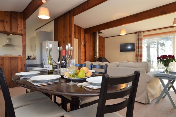 A dining area with a wooden table set for four, surrounded by chairs. - Tranquil location, waterside, pet friendly (Tighnabruaich, Otter Ferry)