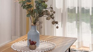 A room with a wooden table, a blue vase with plants, a white lamp, and sheer curtains. - Comfy Studio with Shared Backyard near Racecourse (Carnegie)