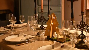 A table set for a meal with wine glasses, plates, and a candle holder. - La Maison d'Anne-Marie, charming vacation rental (Saint-Clet)