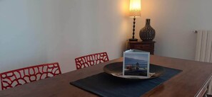 Ein Esstisch mit Platzsetzer, einer dekorativen Lampe und einer Vase auf einem Beistelltisch.