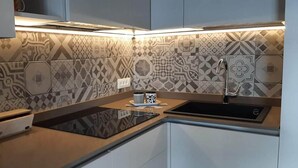 A modern kitchen with patterned tiles, a built-in oven, and a sink. - Casa Maffei TOP apartment 3, 2nd floor, balcony, fantastic lake view, parking (Tignale)